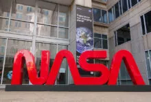 Large red NASA logo in front of the NASA Headquarters building.