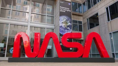 Large red NASA logo in front of the NASA Headquarters building.