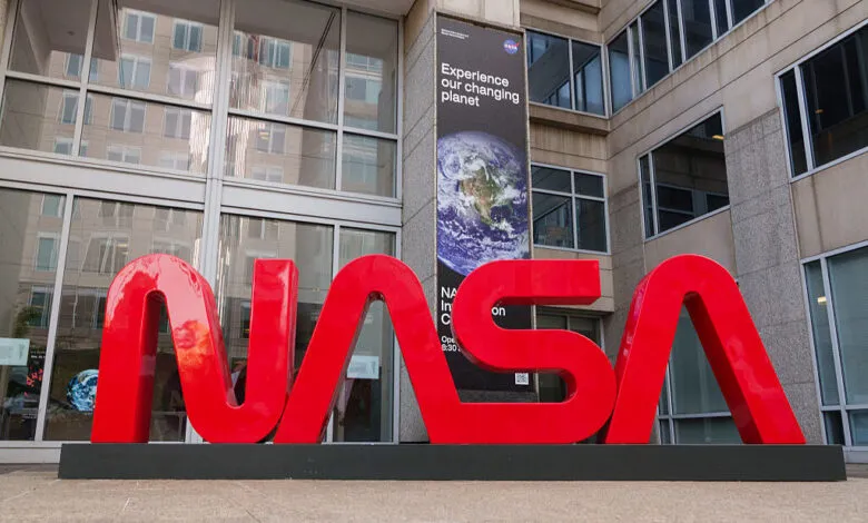 Large red NASA logo in front of the NASA Headquarters building.
