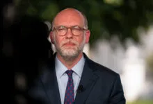 Russell Vought in suit and tie, wearing glasses, looking at camera.