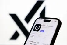 Smartphone displaying Grok AI Assistant app against blurred X logo.