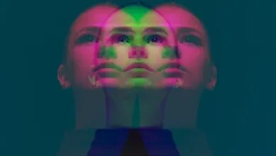 Overlapping faces of a woman in pink and green hues.