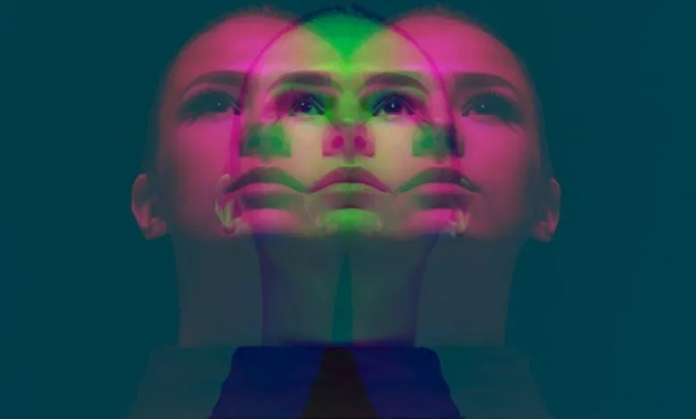 Overlapping faces of a woman in pink and green hues.