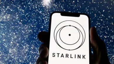 Starlink logo on smartphone screen against a starry night sky background.