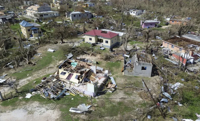 Aerial view of homes damaged by a hurricane, debris scattered around.