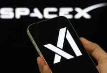 Smartphone displaying xAI logo with SpaceX logo in background.