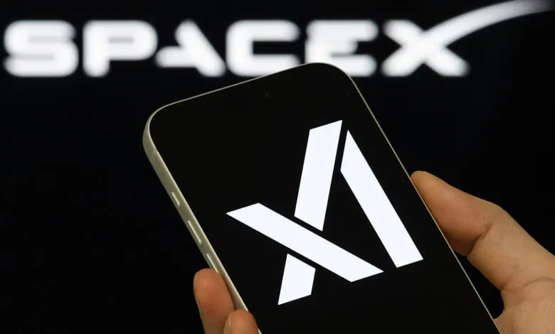 Smartphone displays xAI logo with SpaceX in background.