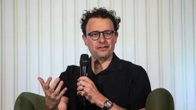 Dario Amodei speaks into microphone, gesturing with hand.
