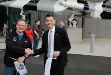 Chris Sembroski and Jared Isaacman shake hands at ribbon cutting.