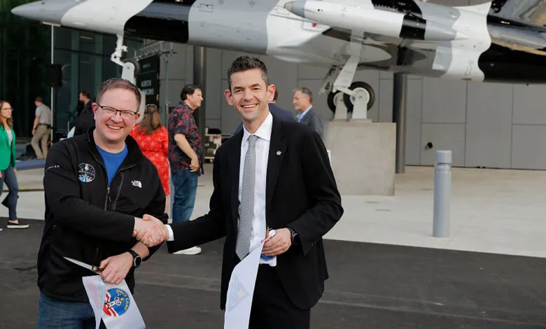 Chris Sembroski and Jared Isaacman shake hands at ribbon cutting.