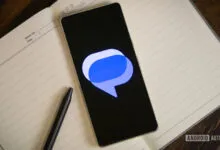 Smartphone displays Google Messages logo on open notebook with pen.