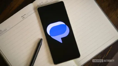Smartphone displays Google Messages logo on open notebook with pen.