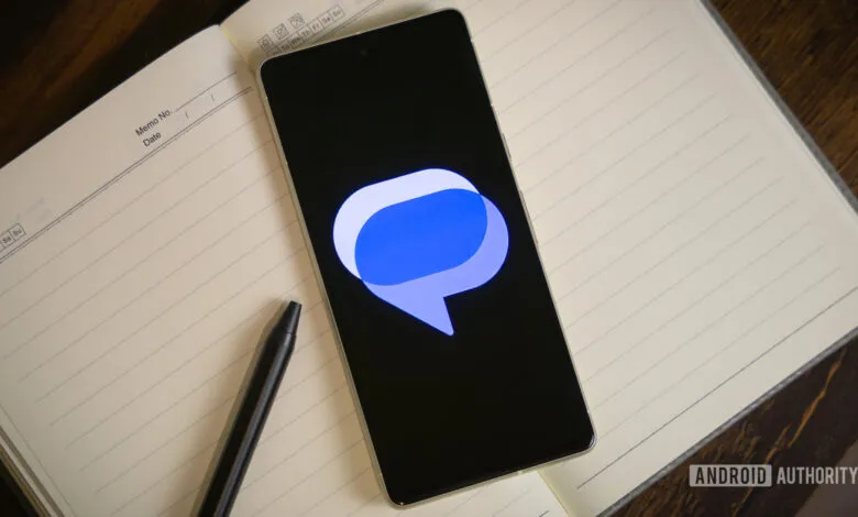 Smartphone displays Google Messages logo on open notebook with pen.