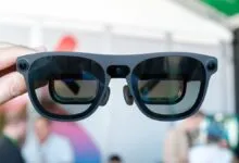Close-up of gray XR smart glasses with reflective lenses being held.