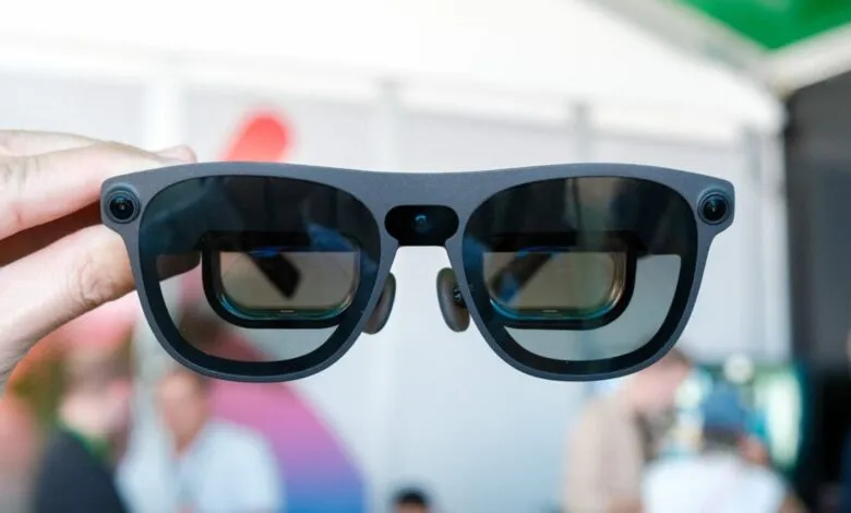 Close-up of gray XR smart glasses with reflective lenses being held.