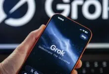 Hand holding phone displaying Grok app with 'Understand the Universe' text.