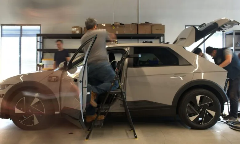 Hyundai Ioniq 5 being worked on by a team in a garage setting.