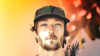 Close-up of a man with blue eyes and a camouflage hat.