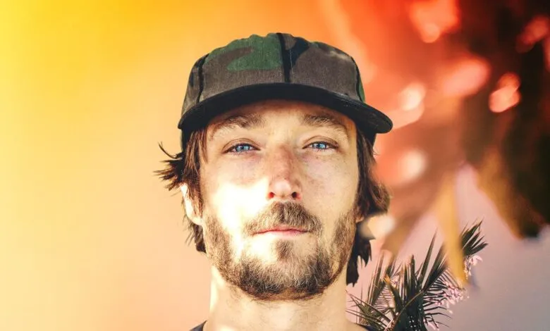 Close-up of a man with blue eyes and a camouflage hat.