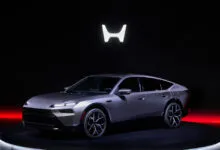 Sleek silver Honda electric sedan prototype on rotating platform.