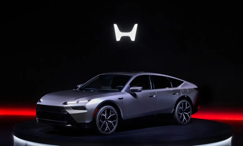 Sleek silver Honda electric sedan prototype on rotating platform.