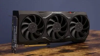 Black Radeon graphics card with three fans on a wooden surface.