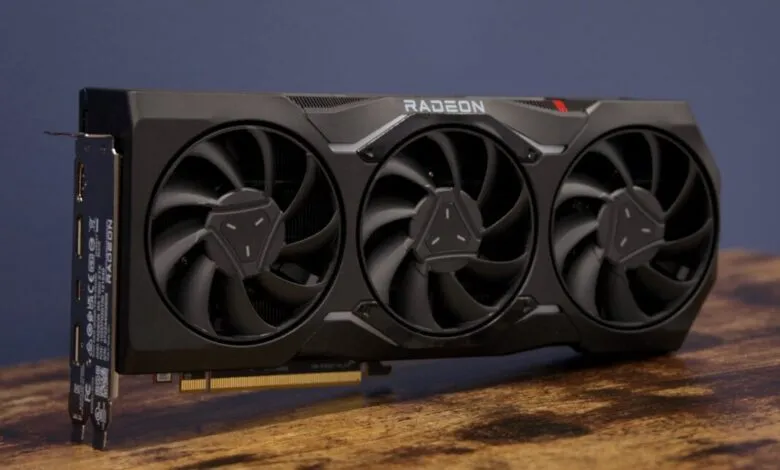 Black Radeon graphics card with three fans on a wooden surface.