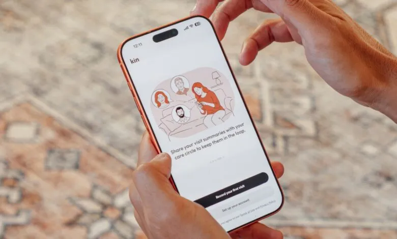 Person holding phone displaying Kin health app interface.