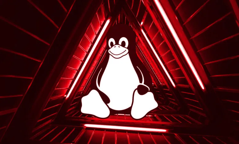 Tux the Linux penguin inside a red triangular tunnel with bright lights.
