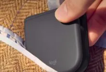 Logitech folding mouse being placed into a tweed jacket pocket.