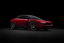 Sleek red Ferrari Purosangue SUV with black accents on a dark background.