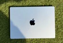 Silver Apple MacBook Pro resting on bright green artificial grass.