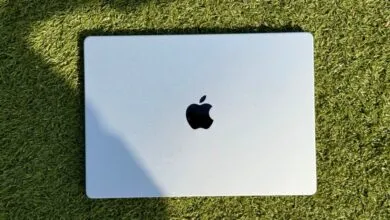 Silver Apple MacBook Pro resting on bright green artificial grass.