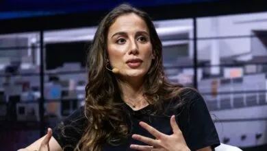 Mira Murati speaks at a conference, gesturing with her hands.