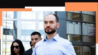 Ilya Sutskever walks with colleagues outside a modern building.