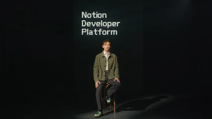 Person sits in front of screen displaying 'Notion Developer Platform'.