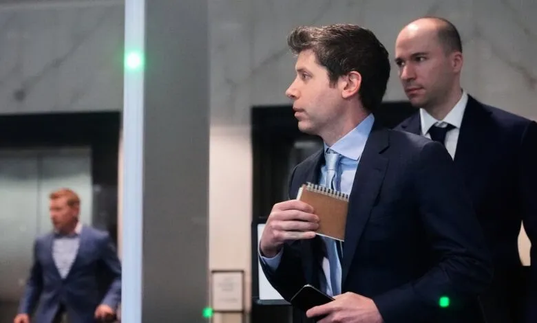Two men in suits walk through a doorway, one holding a notebook.