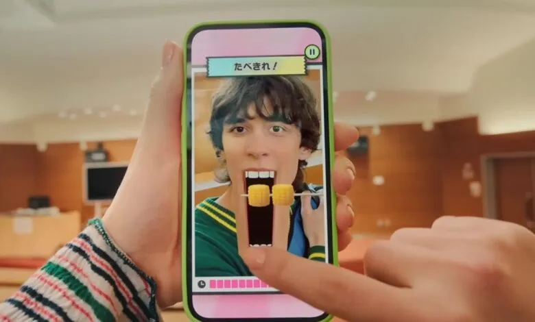 Person playing a mobile game with a face filter eating virtual corn.
