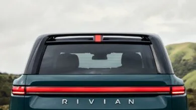 Rear view of a Rivian vehicle with distinctive horizontal taillight and 'RIVIAN' lettering.