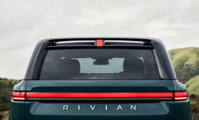 Rear view of a Rivian vehicle with distinctive horizontal taillight and 'RIVIAN' lettering.