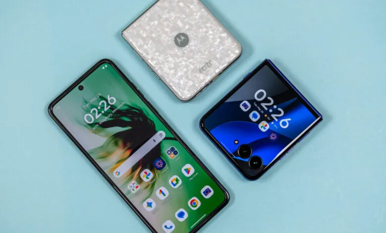 Three Motorola Razr phones displayed on a light blue surface, showcasing different designs.