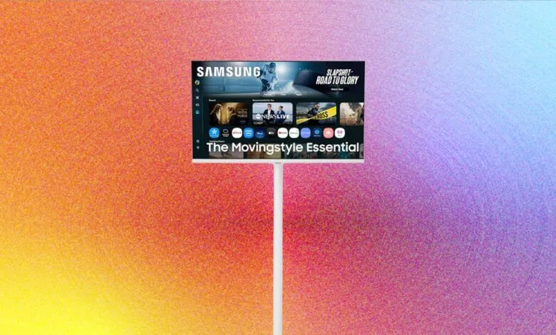 Samsung Movingstyle Essential TV on a stand against a colorful gradient background.