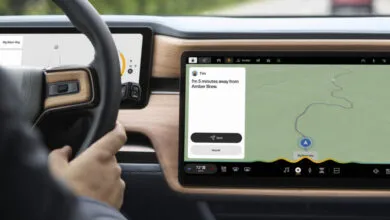 Rivian dashboard showing navigation and messaging features, driver's hand on the wheel.