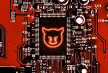 Close-up of a red circuit board with a glowing devil icon on the central chip.