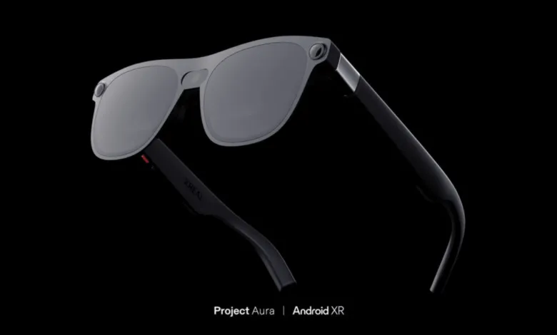 XREAL Project Aura Android XR glasses with gray lenses and black frames.