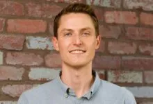 Sean Henry, CEO of Stord, poses against a brick wall.