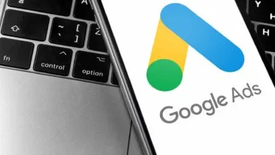 Google Ads logo displayed on a phone next to a laptop keyboard.