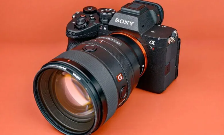 Sony Alpha 7R V camera with lens on orange background.