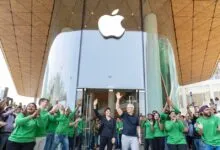 Tim Cook and Deirdre O'Brien wave at Apple BKC store opening in Mumbai.