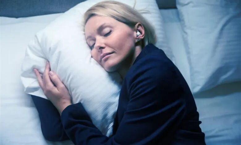 Woman in business suit sleeps peacefully in bed with earplugs.